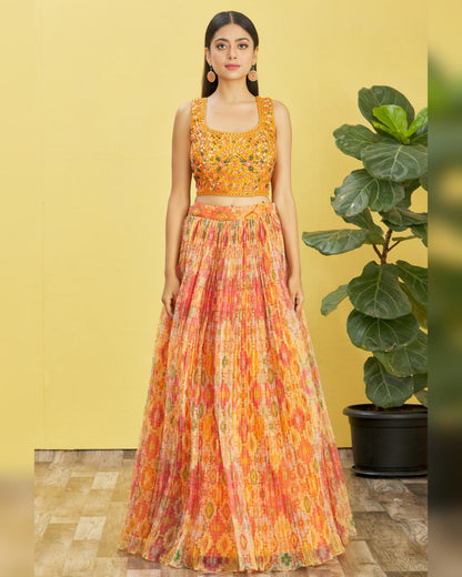 Woman wearing a colorful outfit with a yellow background and plant.