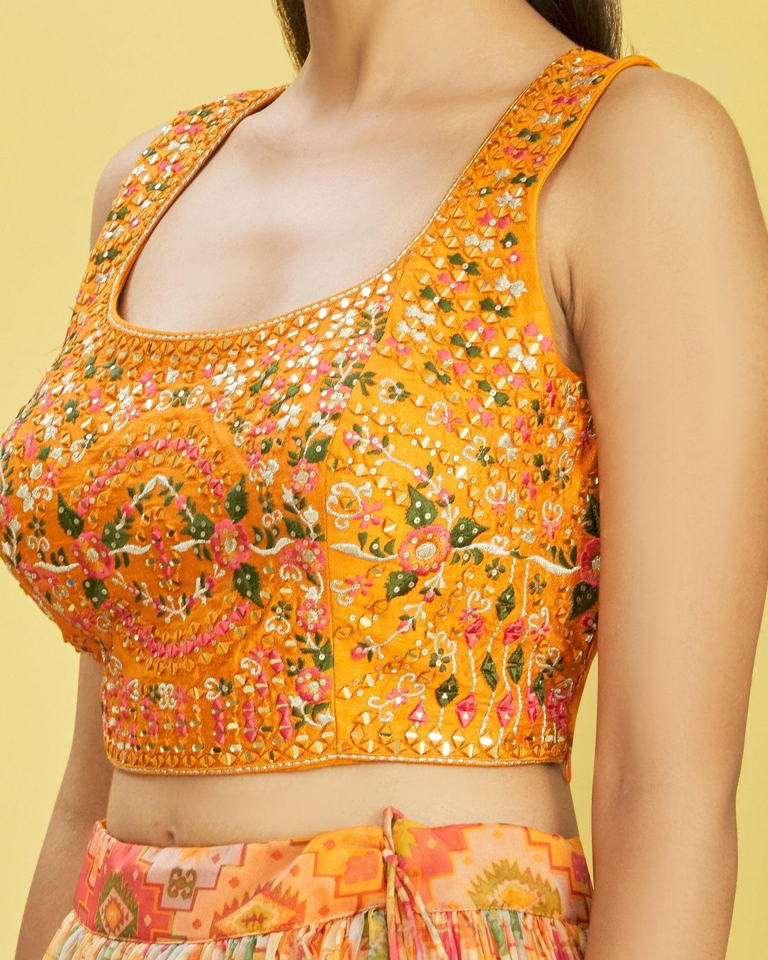 Orange floral patterned top on a yellow background