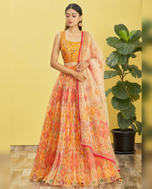 Woman wearing a colorful traditional outfit with a yellow background and plant.