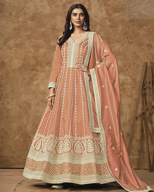 Woman wearing a traditional pink and white embroidered outfit against a brown background