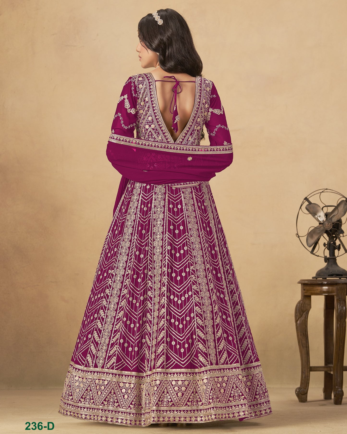 Woman wearing a purple and white patterned dress against a beige background