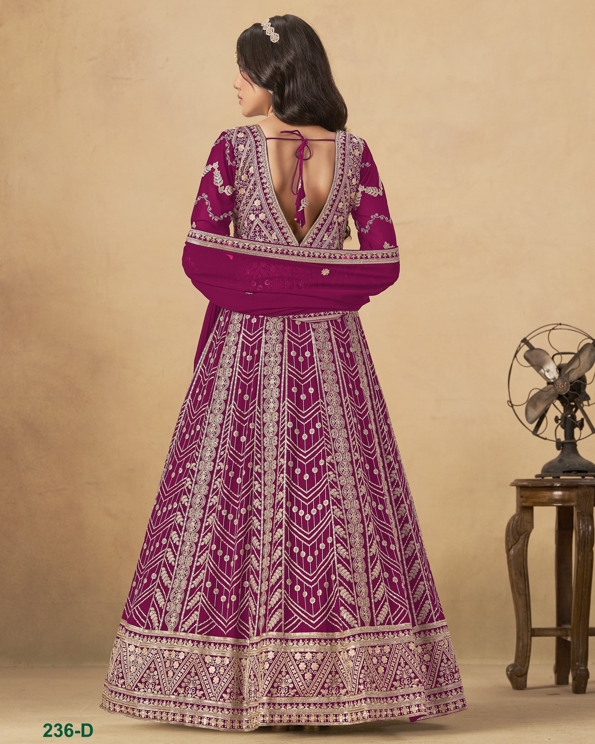 Woman wearing a purple and white patterned dress against a beige background