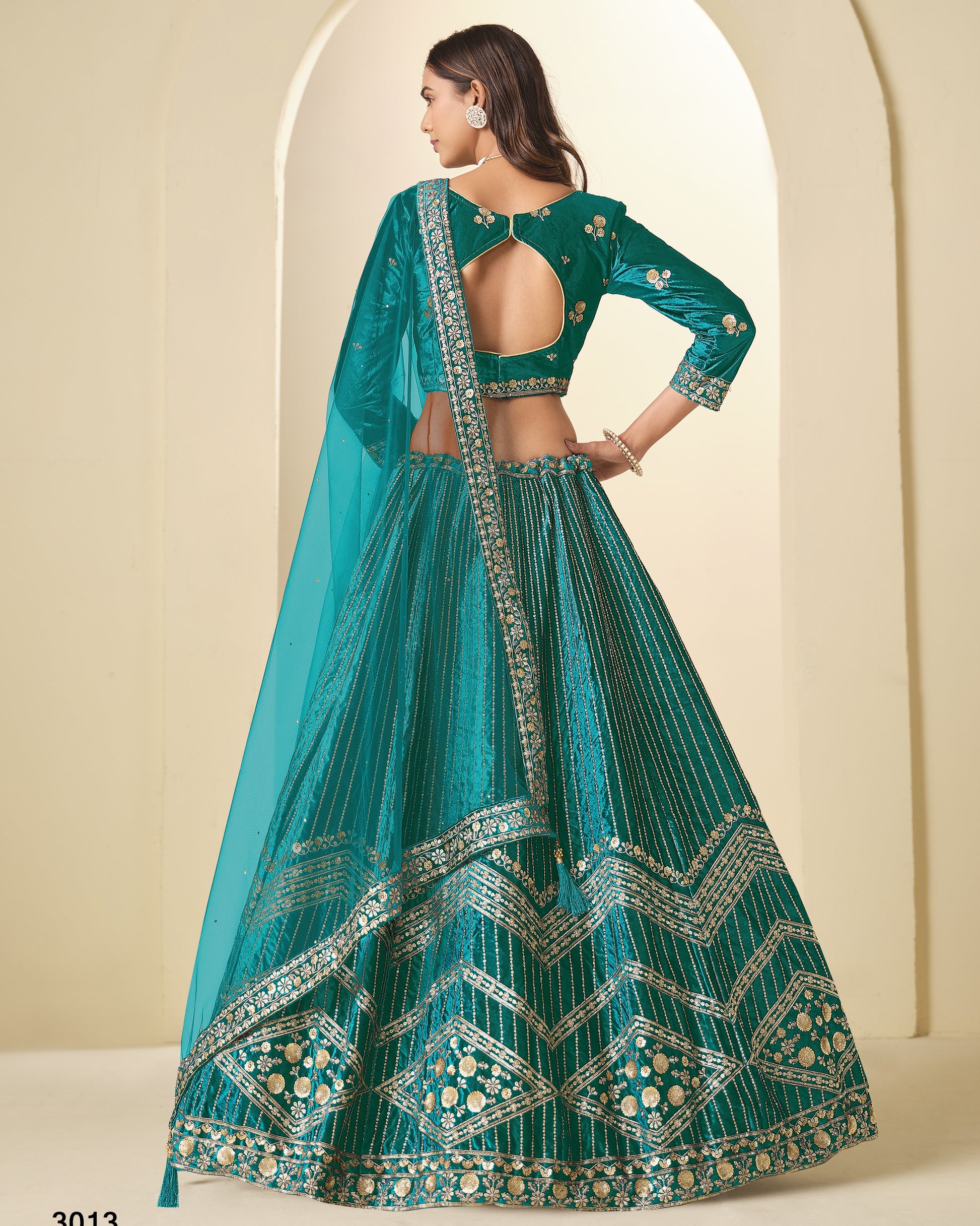 Teal embroidered traditional outfit with a plain background