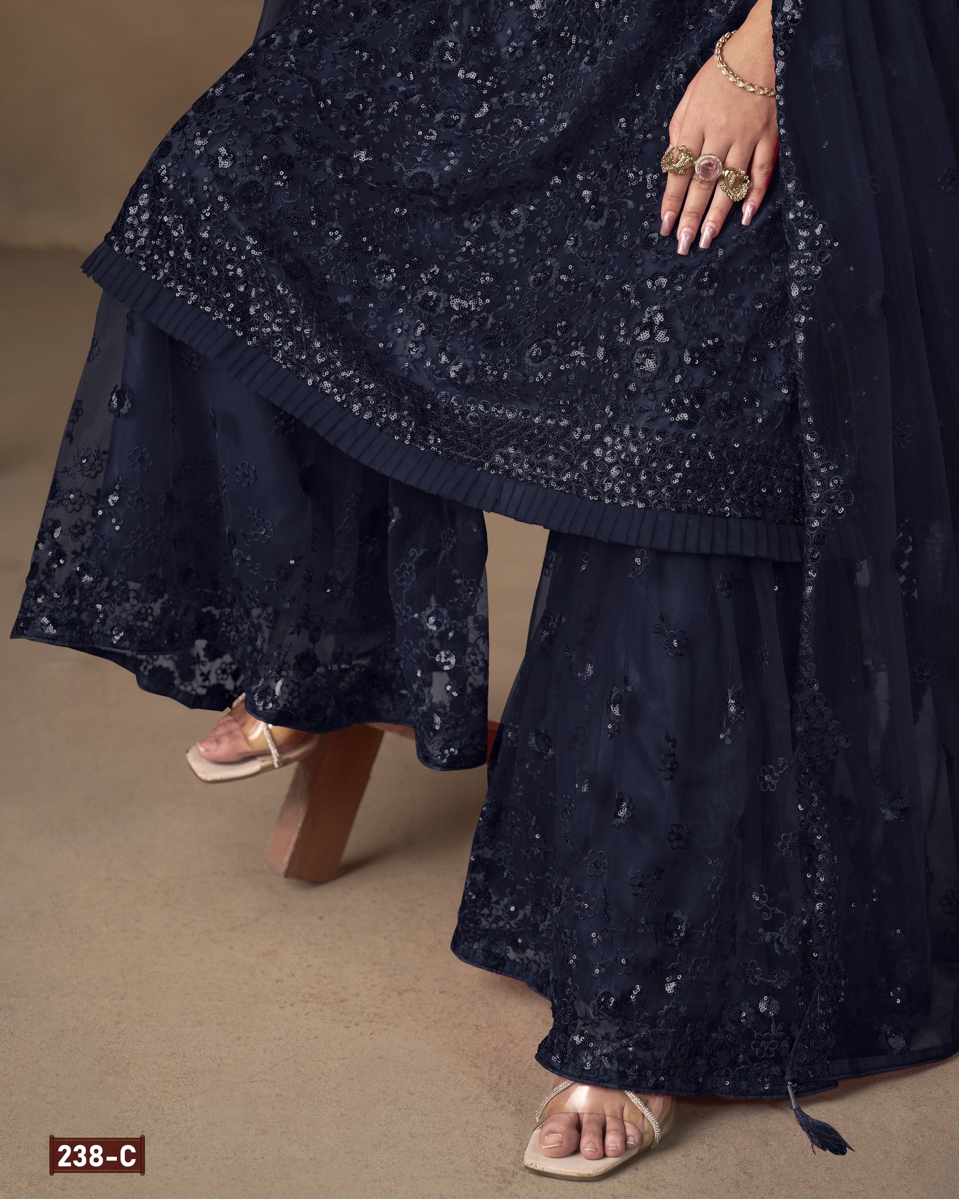 Navy blue embroidered traditional outfit on a beige background