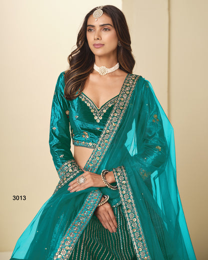 Woman wearing a teal traditional outfit with intricate designs on a beige background
