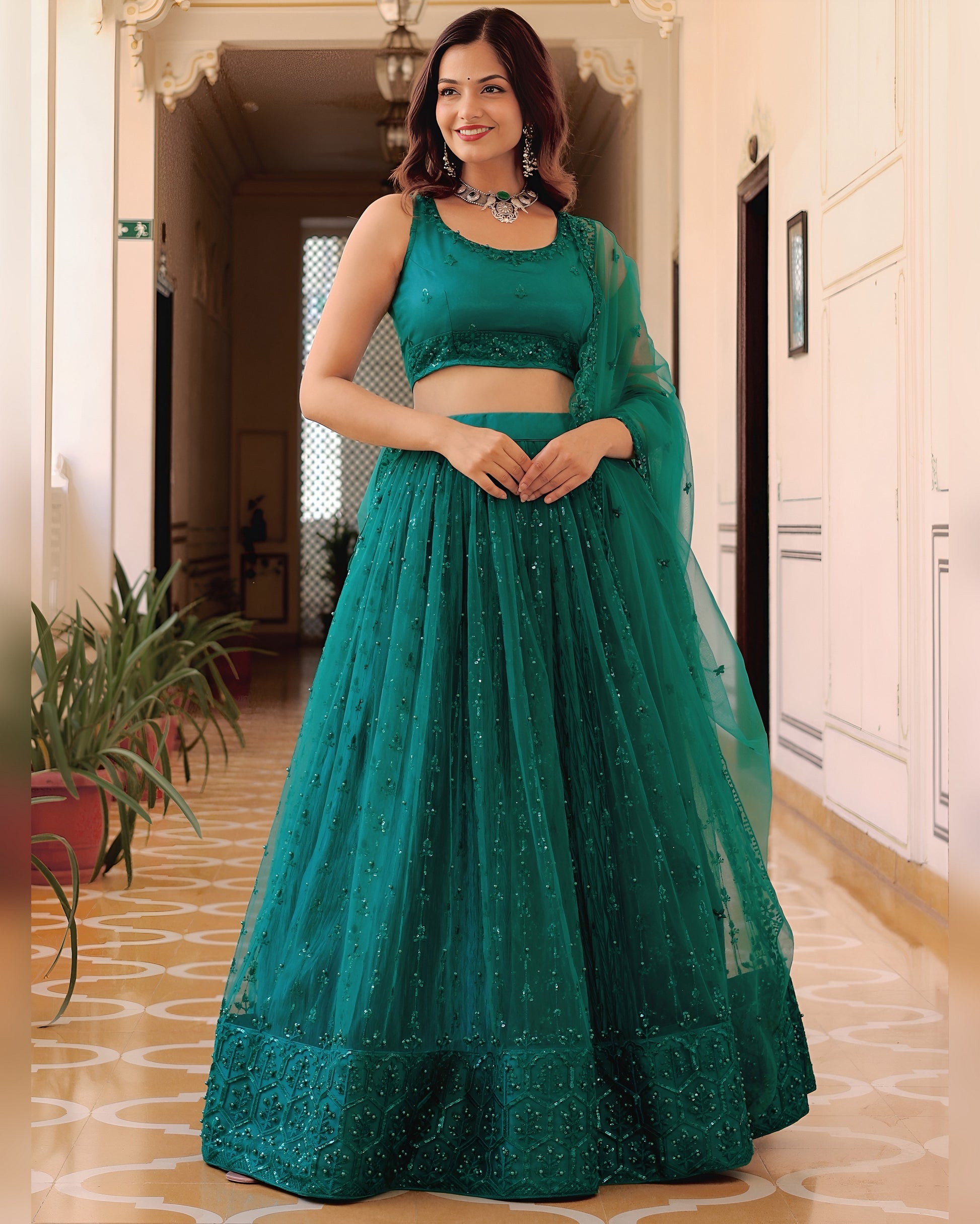Woman wearing a teal traditional outfit indoors