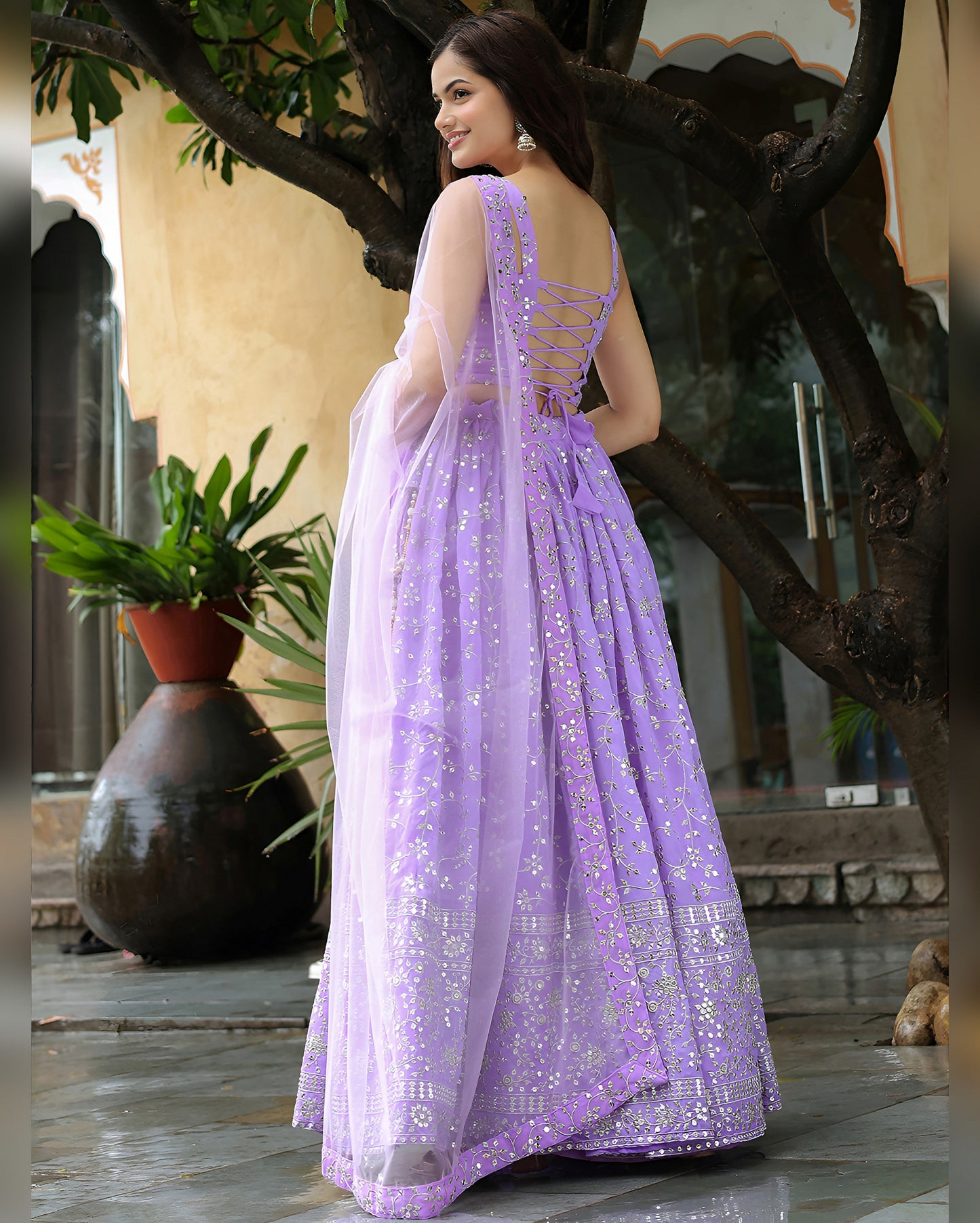 Woman in a lavender saree with a floral background