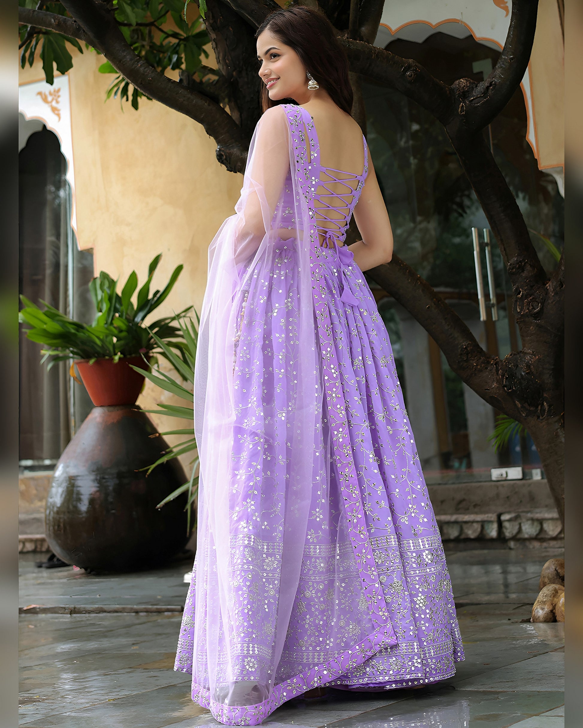 Woman in a lavender saree with a floral background