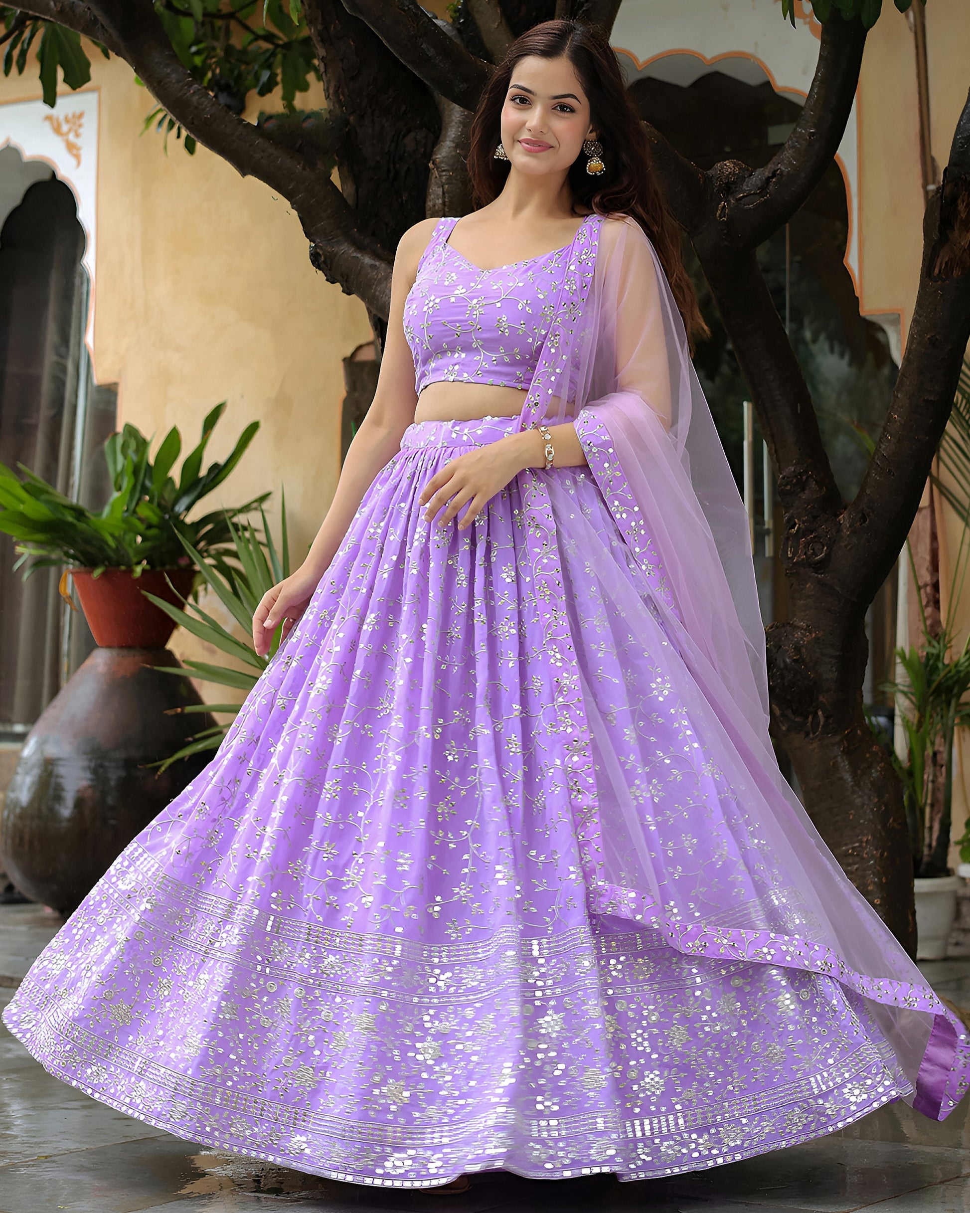 Woman wearing a purple embroidered lehenga in an outdoor setting