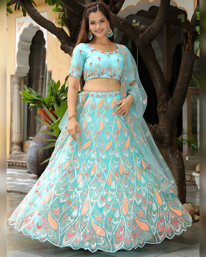 Woman in a light blue traditional outfit with floral patterns standing outdoors.