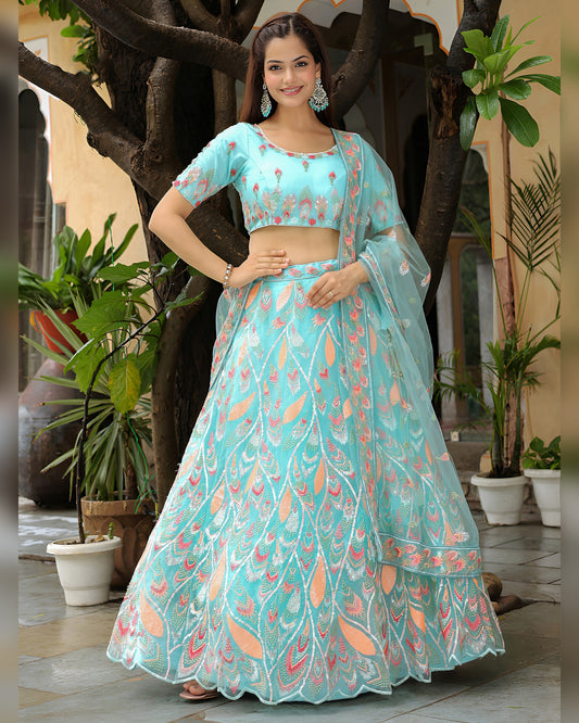 Woman in a light blue floral outfit standing outdoors with plants around