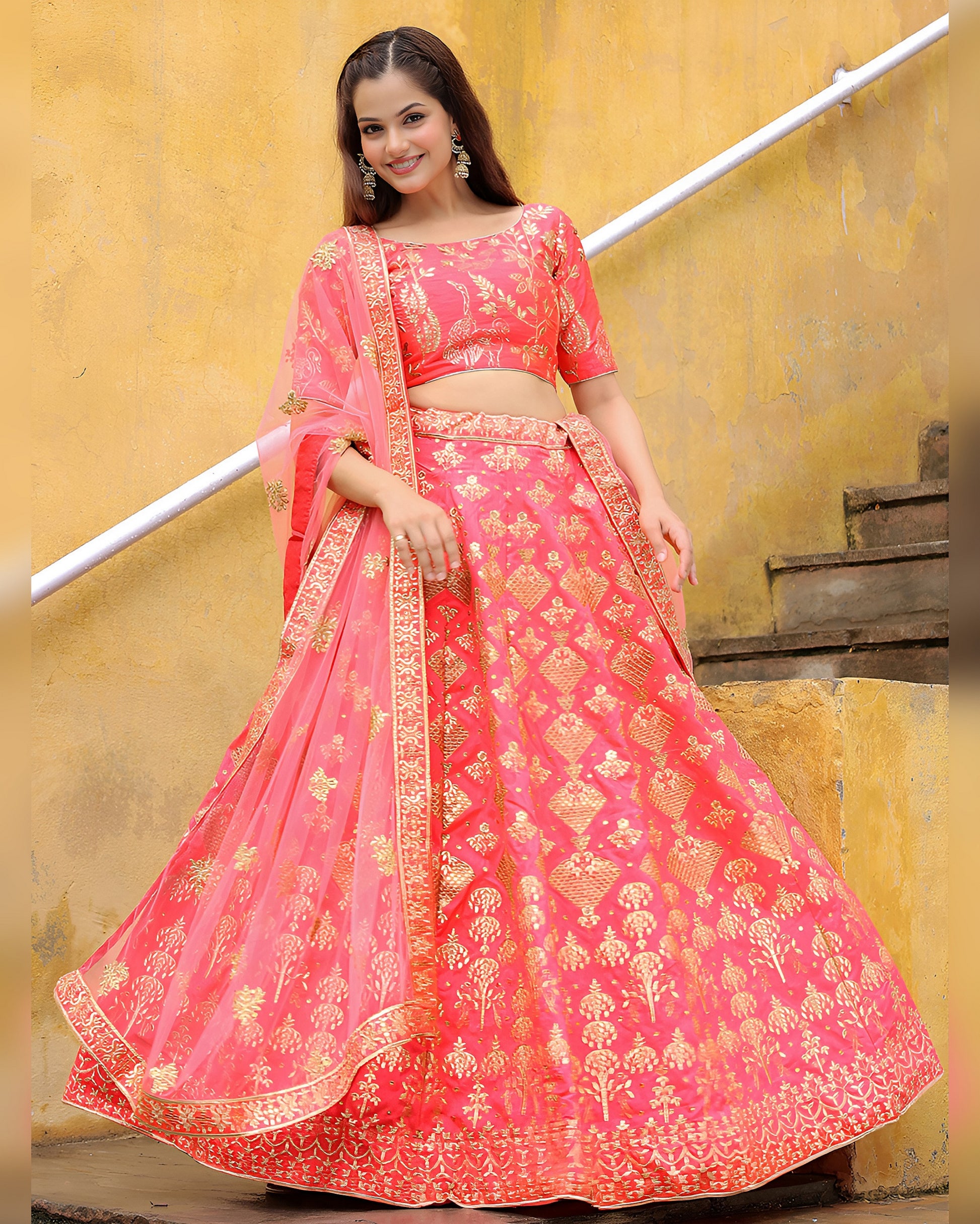 Woman wearing a pink embroidered lehenga with a yellow wall background