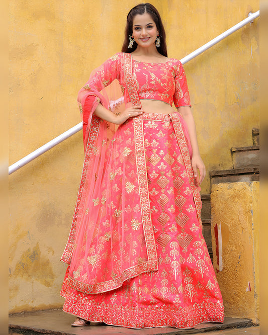 Woman in a pink traditional outfit with gold embroidery against a yellow wall.