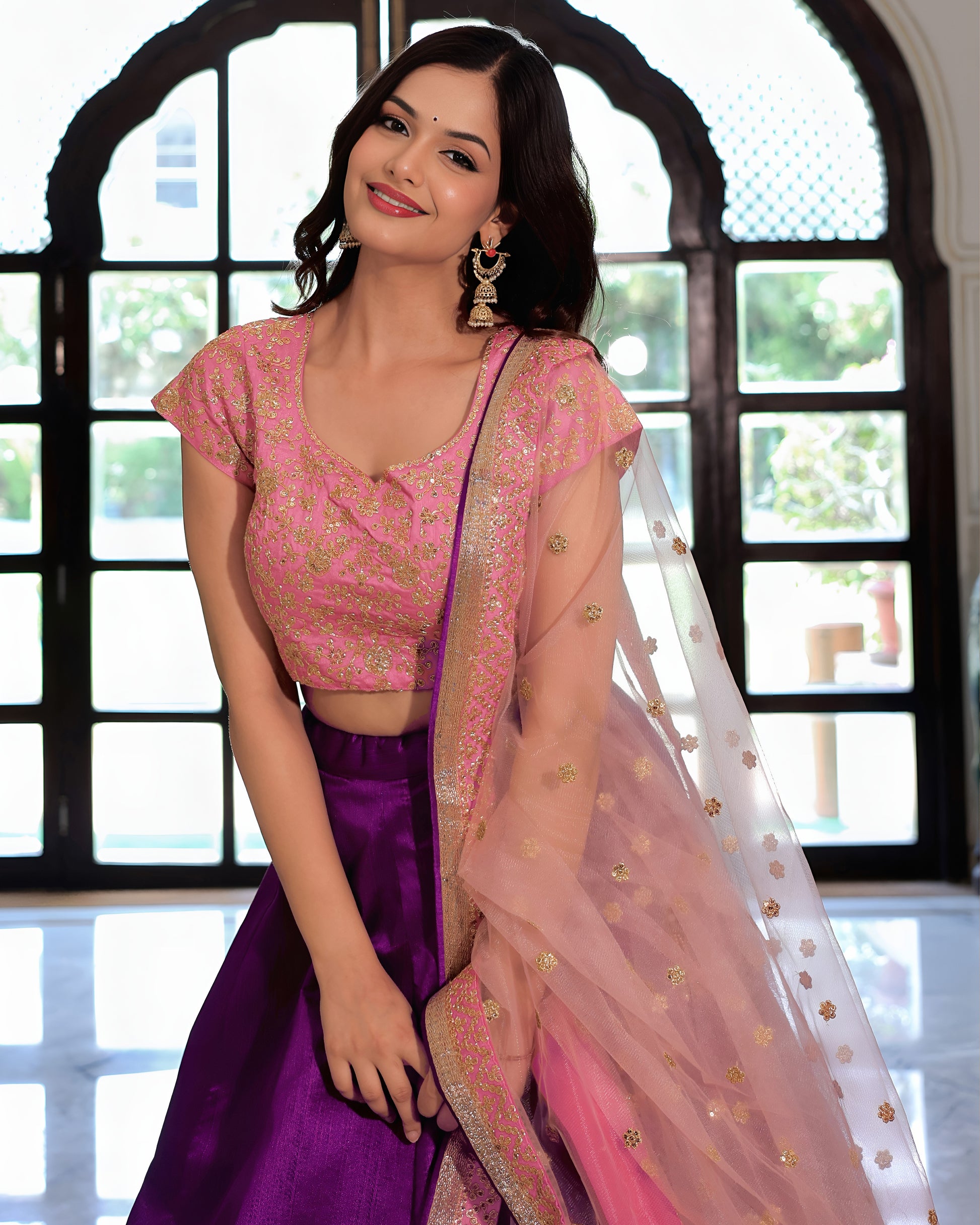 Woman wearing a pink and purple traditional outfit with a blurred background