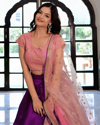 Woman wearing a pink and purple traditional outfit with a blurred background
