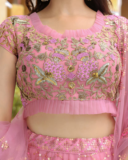 Pink embroidered blouse with gold details on a blurred background