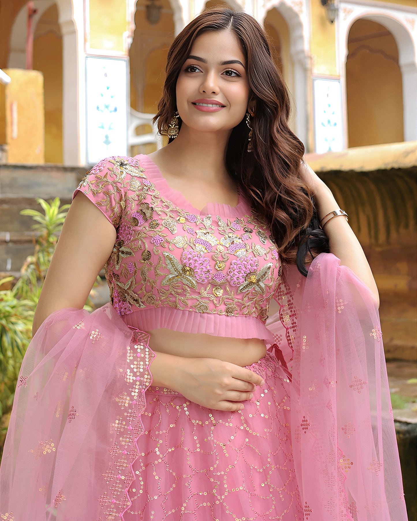 Woman in a pink traditional outfit with floral patterns in an outdoor setting