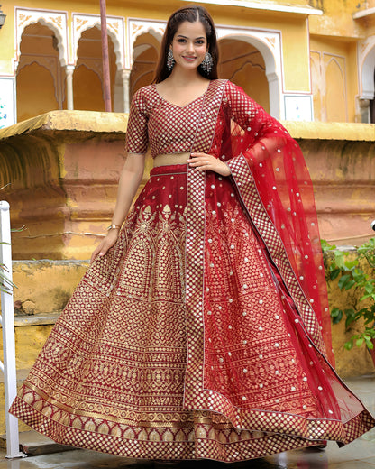 Woman in a red and gold traditional outfit standing in front of architectural background
