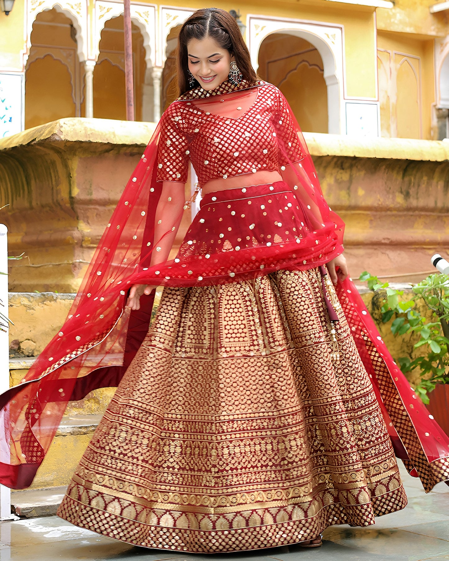 Woman in a traditional red and gold outfit with a decorative background