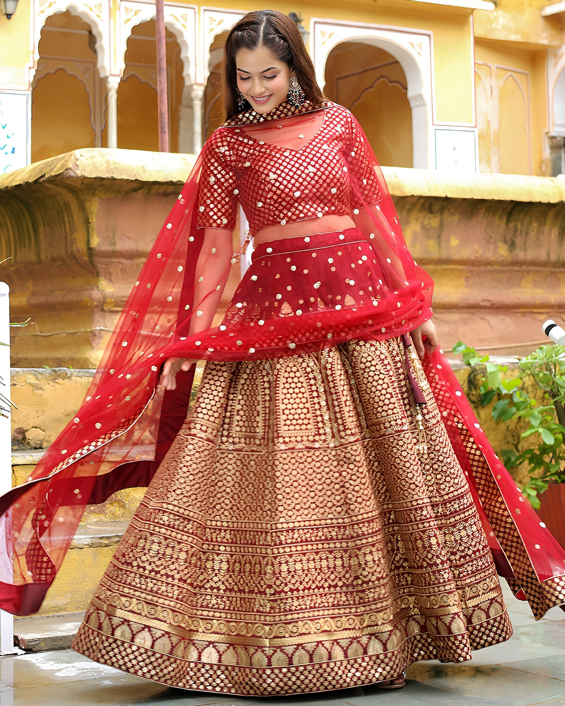 Woman in a traditional red and gold outfit with a decorative background