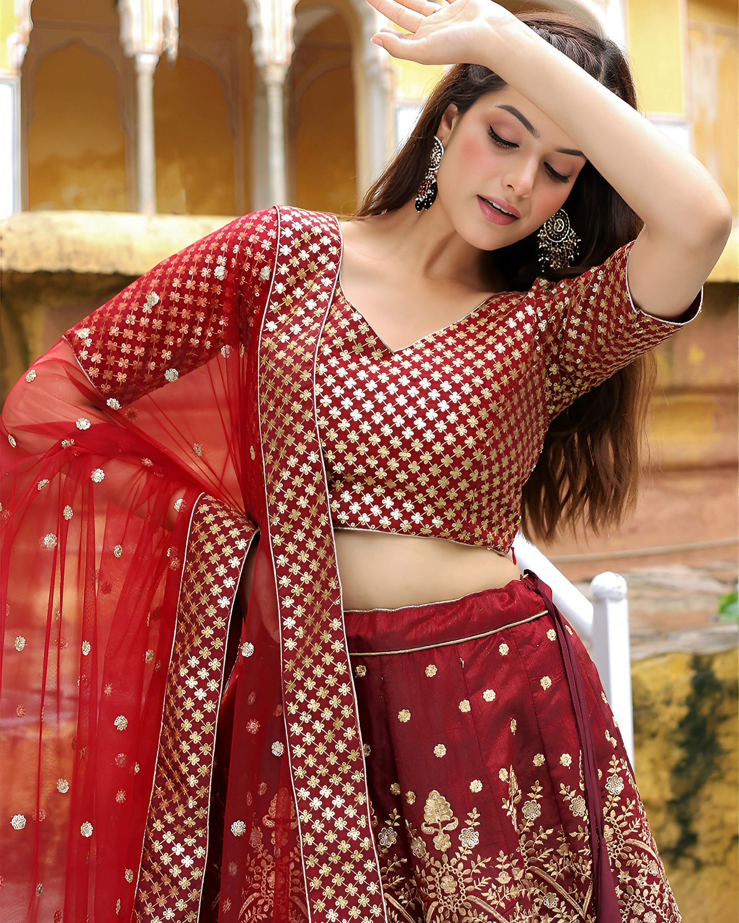 Woman in a red and gold traditional outfit with a blurred background