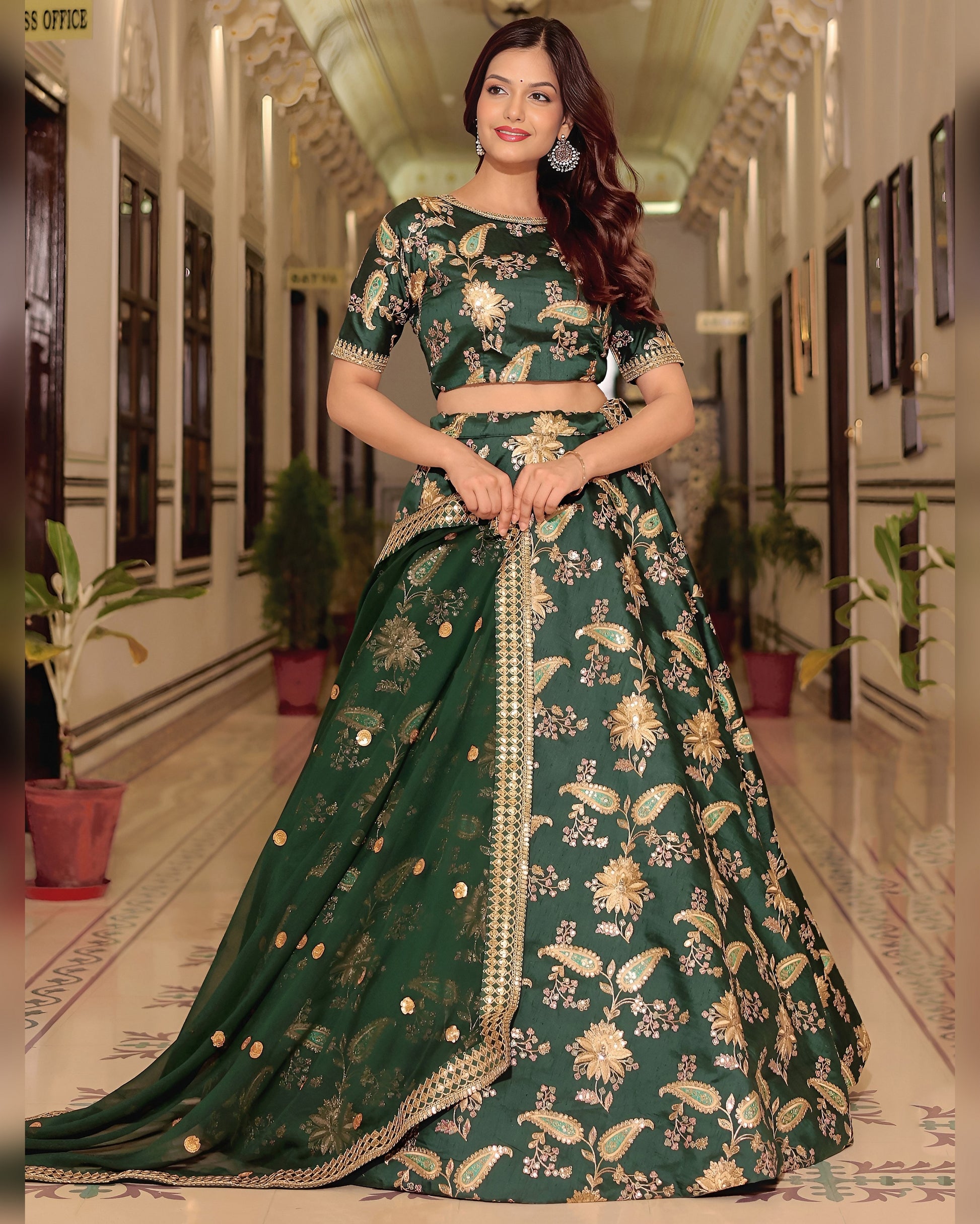 Woman wearing a green floral lehenga in an indoor setting