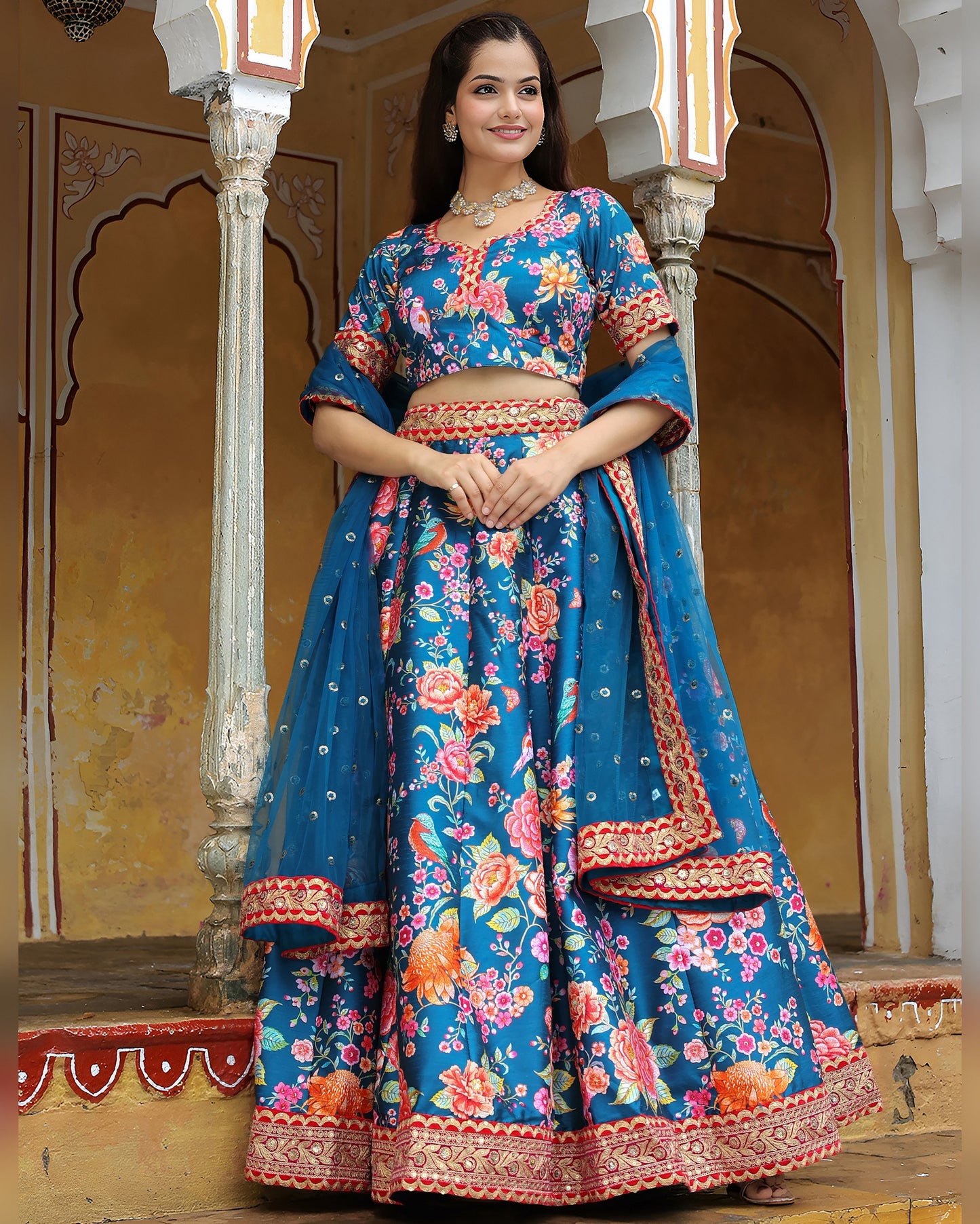Woman wearing a blue floral traditional outfit in an ornate indoor setting
