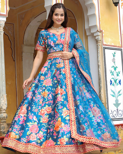 Woman wearing a blue floral dress with intricate patterns in an ornate setting.