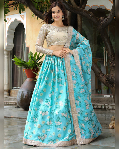 Woman in a blue floral lehenga with beige blouse standing outdoors.