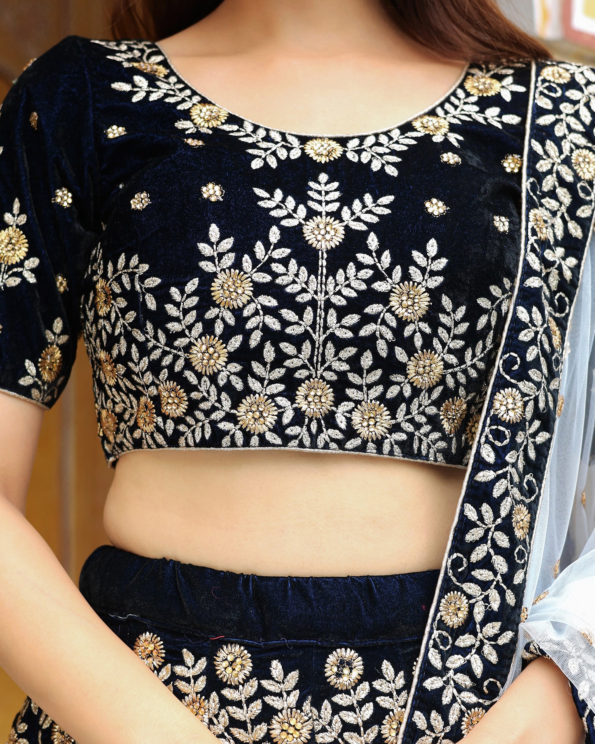 Navy blue embroidered blouse with gold details on a person