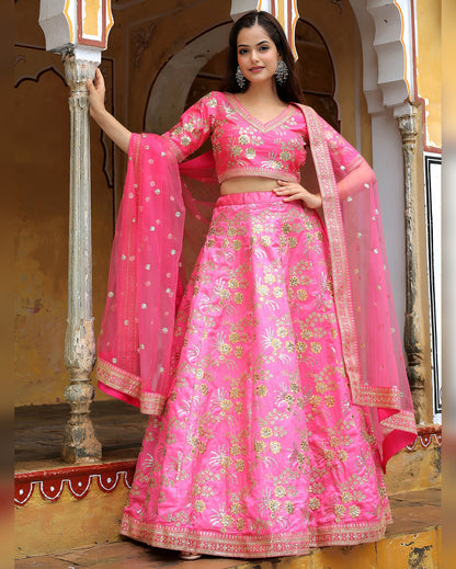 Woman in a pink traditional outfit with gold embroidery in an ornate setting