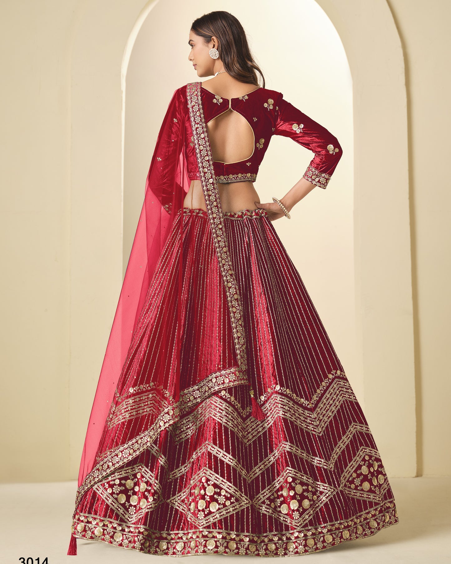 Red embroidered traditional outfit with a pink dupatta against a neutral background