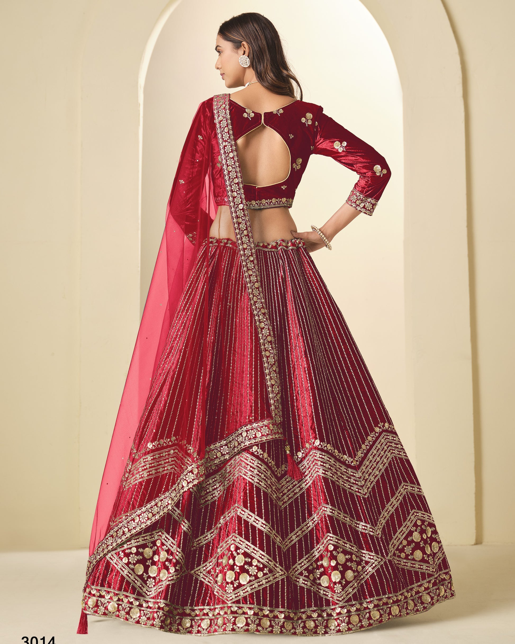 Red embroidered traditional outfit with a pink dupatta against a neutral background