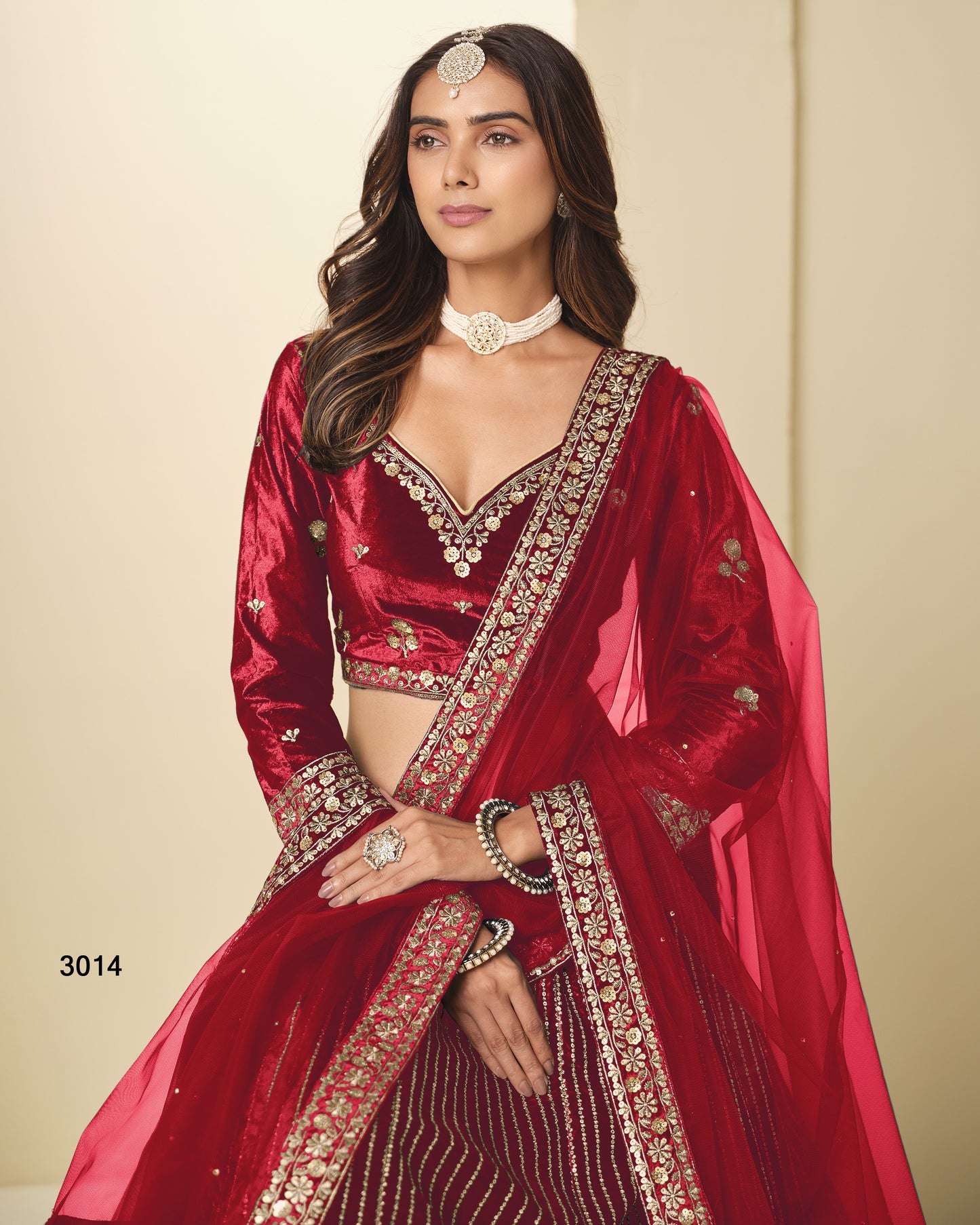 Woman wearing a red traditional outfit with intricate designs on a beige background