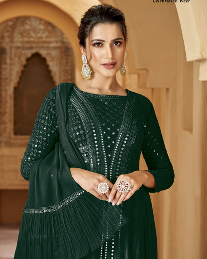 Woman in a dark green traditional outfit with jewelry against an architectural background