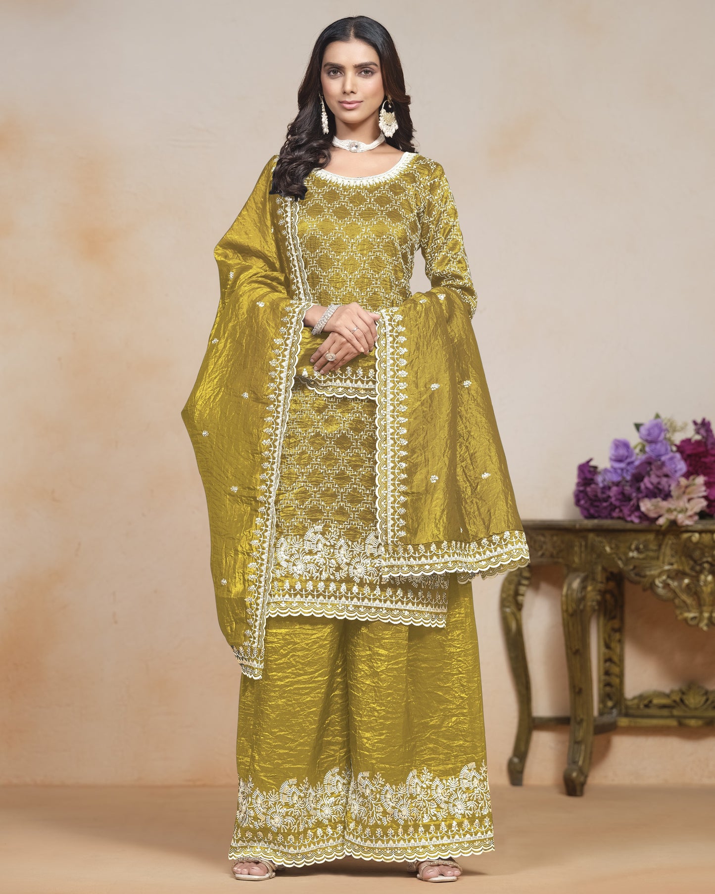 Woman wearing a green embroidered traditional outfit with a beige background