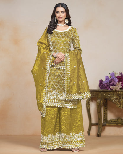 Woman wearing a green embroidered traditional outfit with a beige background