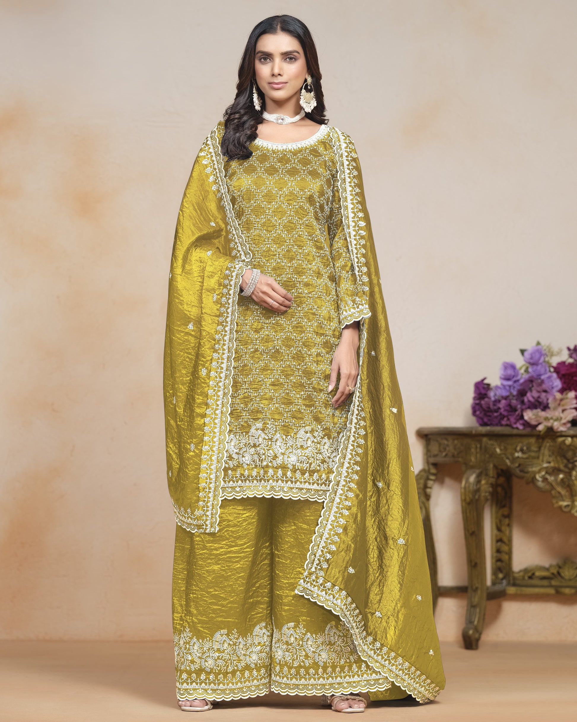 Woman wearing a green embroidered traditional outfit with a beige background