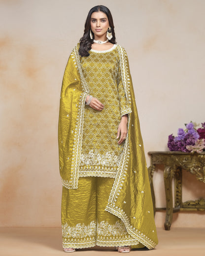 Woman wearing a green embroidered traditional outfit with a beige background