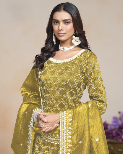 Woman wearing a yellow traditional outfit with white embroidery against a neutral background