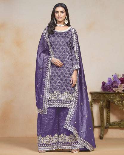 Woman wearing a purple embroidered traditional outfit with a beige background