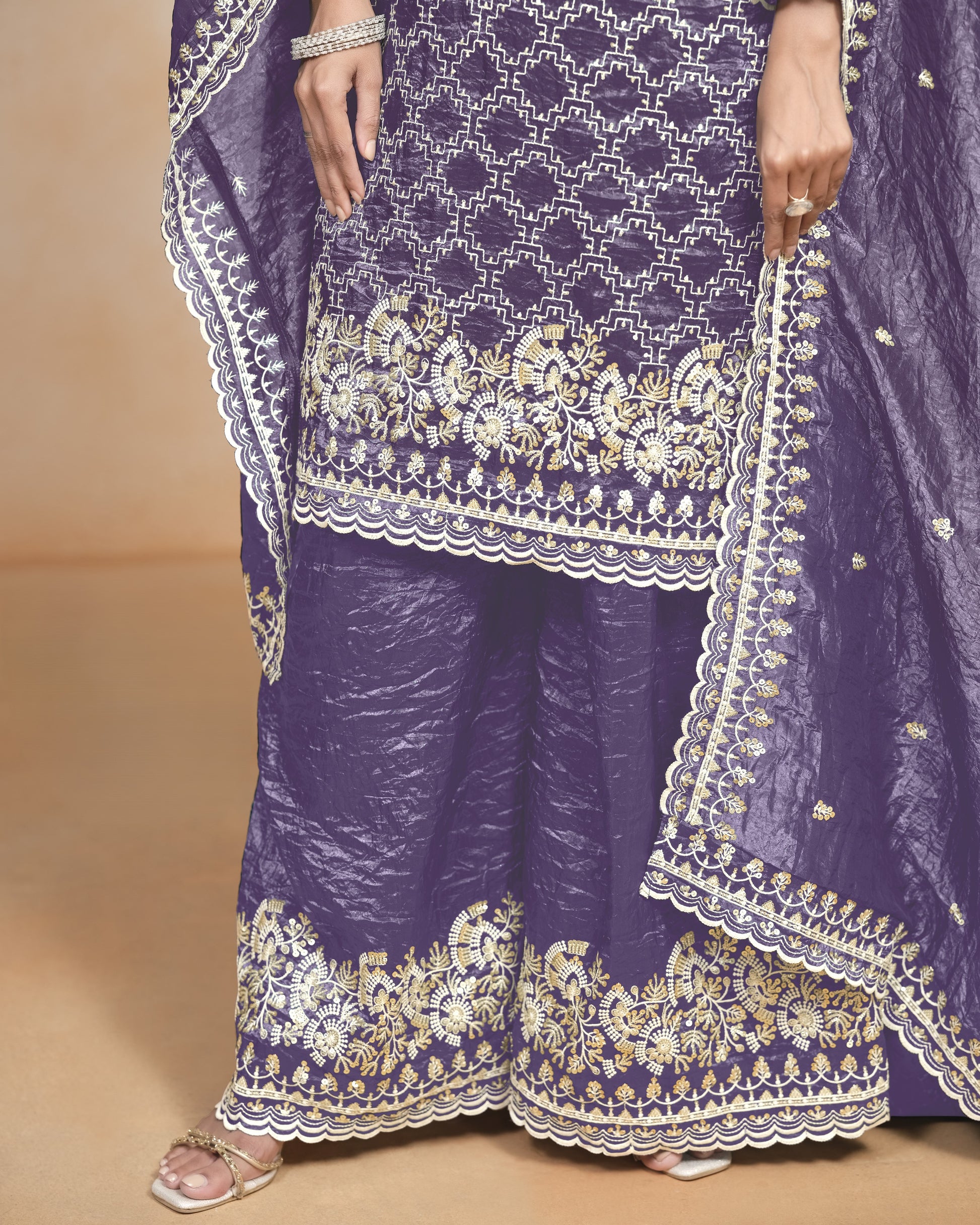 Purple traditional outfit with white embroidery on a beige background