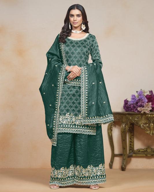 Woman wearing a green embroidered traditional outfit with a beige background