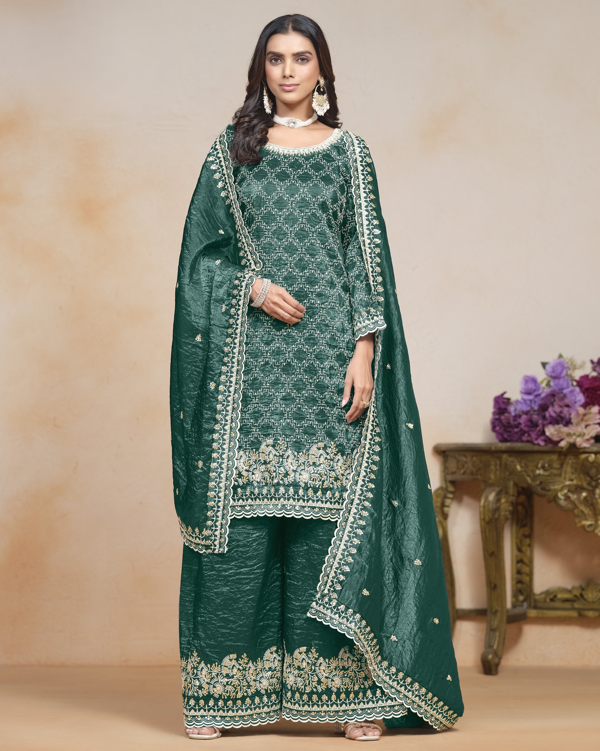 Woman wearing a green embroidered traditional outfit with a beige background