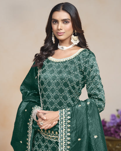Woman wearing a green traditional outfit with white embroidery against a beige background
