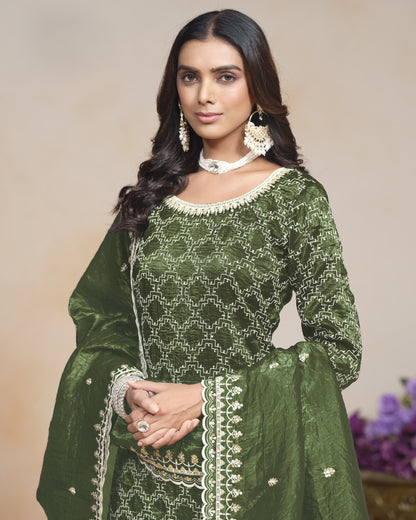 Woman wearing a green embroidered traditional outfit with a neutral background