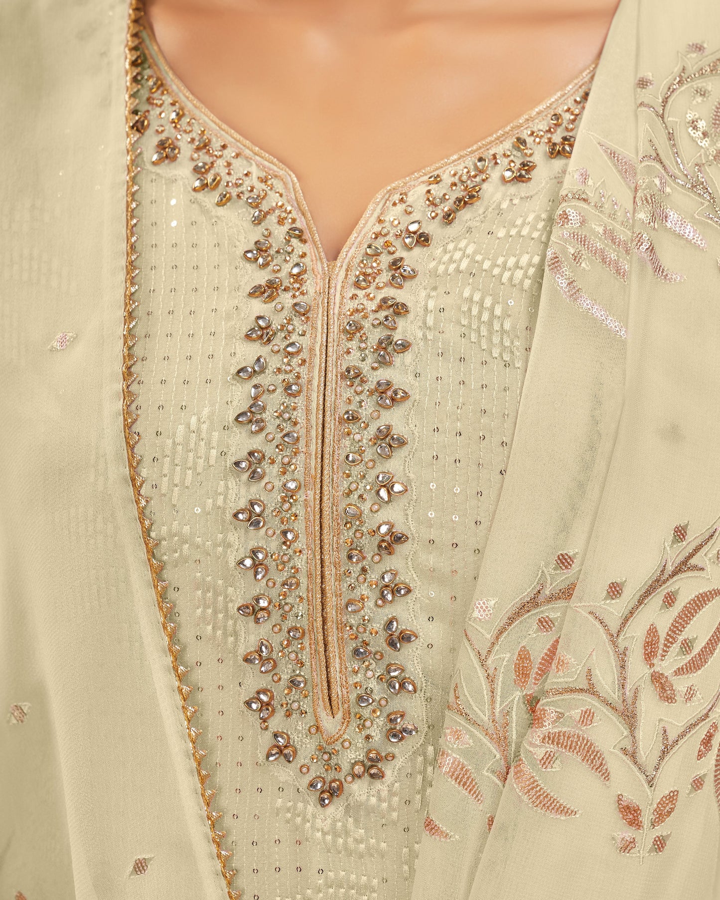 Close-up of a light green embroidered garment with intricate patterns.