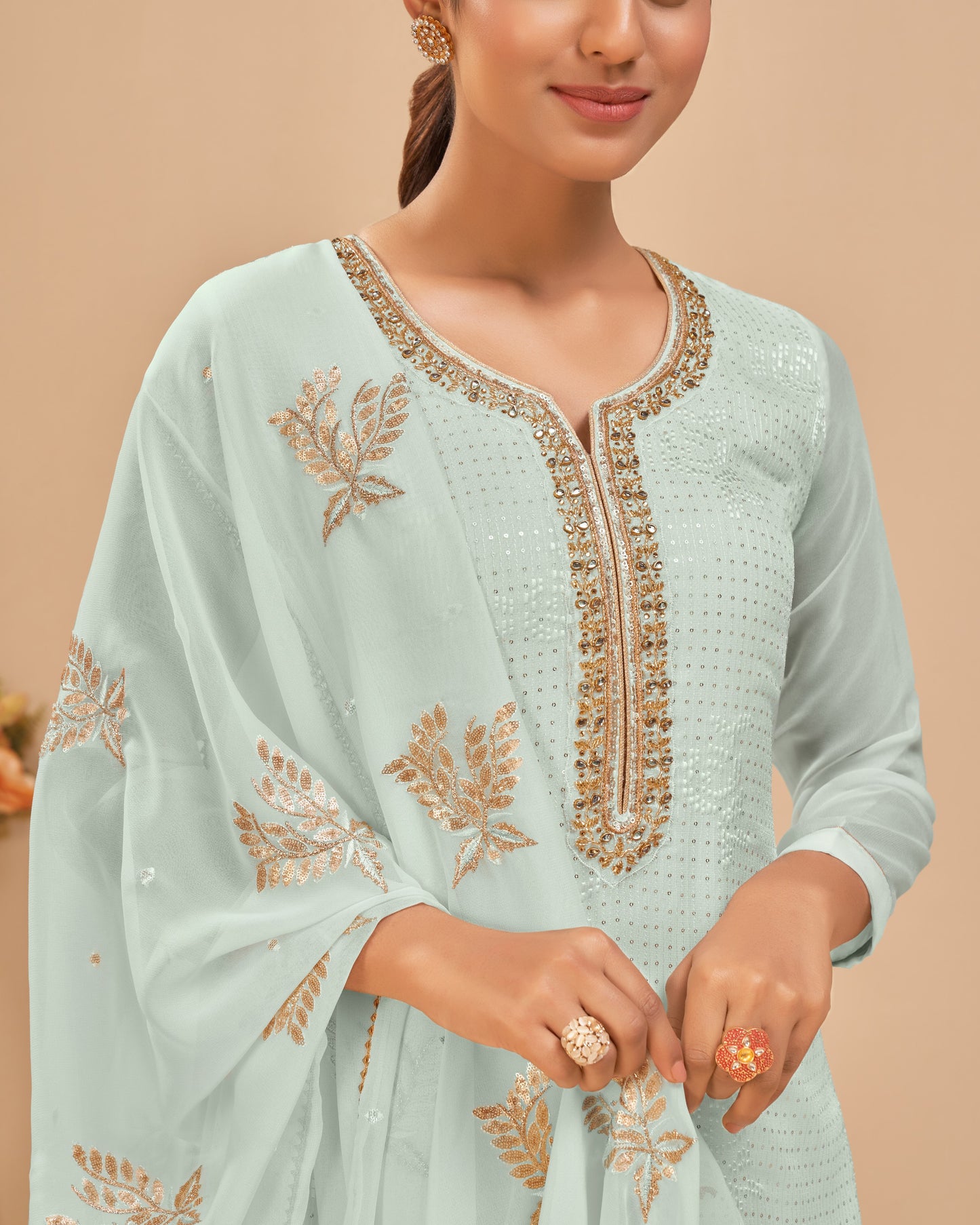 Light blue traditional outfit with gold embroidery on a beige background