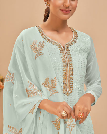 Light blue traditional outfit with gold embroidery on a beige background