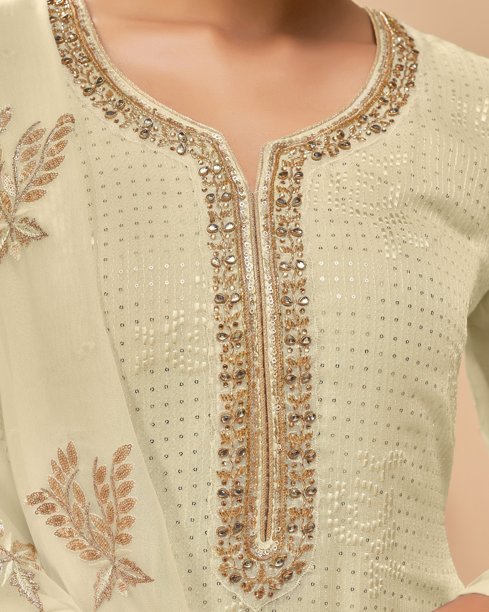 Close-up of a cream-colored garment with intricate gold embroidery